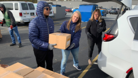Perdue associates Destinee Duffy, Holly Porter and Kim Huey load boxes of food into a vehicle.