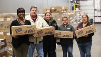 Food Bank of the Albemarle team members hold some of the 40,000 pounds of chicken donated by Perdue Farms.