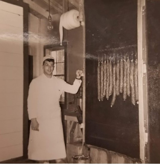 Merlyn Eickman standing next to the smokehouse