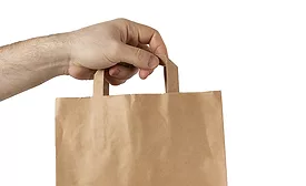 man's hand hold a paper bag of craft paper on an isolated white background.