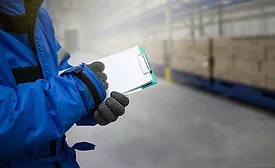 Closeup shooting hand of worker with clipboard checking goods in freezing room or warehouse