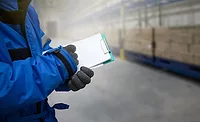 Closeup shooting hand of worker with clipboard checking goods in freezing room or warehouse Closeup shooting hand of worker with clipboard checking goods in freezing room or warehouse