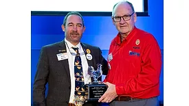 USPOULTRY president Nath Morris presents the Harold E. Ford Lifetime Achievement Award to former USPOULTRY president John Starkey at the 2024 IPPE