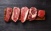 Variety of Raw Black Angus Prime meat steaks Machete, Blade on bone, Striploin, Rib eye, Tenderloin fillet mignon on wooden board copy space Variety of Raw Black Angus Prime meat steaks Machete, Blade on bone, Striploin, Rib eye, Tenderloin fillet mignon on wooden board copy space