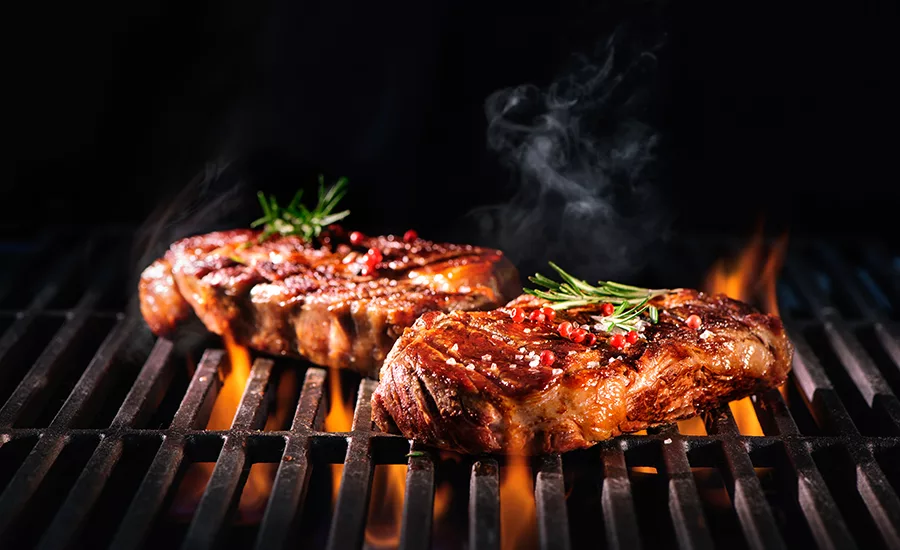 Beef steaks on the grill with flames