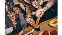 People eating Wingstop chicken tenders together at a table