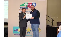 North Carolina Commissioner of Labor Luke Farley presents award to Case Farms Safety Manager Jared Birchum.