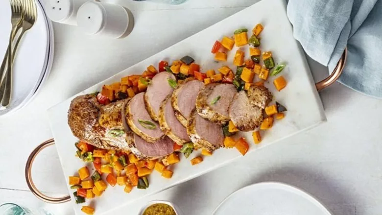 Garlic Dijon pork tenderloin served with roasted sweet potatoes and bell peppers