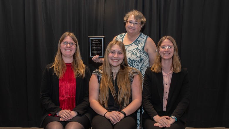 Bonnie Walters of the University of Wisconsin River Falls, recognized for 34 years of coaching service, is pictured with her poultry judging team. 