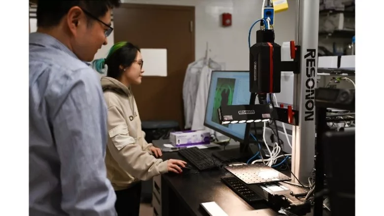 Lead researcher Yiming Feng (left) looks on as postdoctoral researcher and coauthor Ran Yang uses hyperspectral imaging to scan a tilapia fillet for microplastic contamination