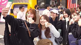 Participants at the Shibuya-Omotesando Women’s Fun Run in central Tokyo eat samples of American salad pork.