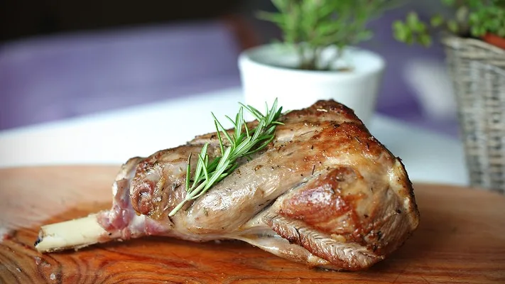 Roasted leg of lamb with rosemary on the cutting board