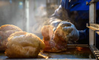 hand cutting a rotisserie chicken