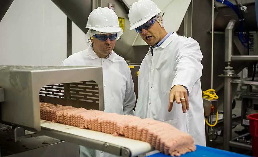 Andy Hanacek and Frank Koekkoek Jr., complex manager for Raeford, talk about the startup of the ground turkey tray-pack line running during Hanacekâs visit to the new facility in mid-November