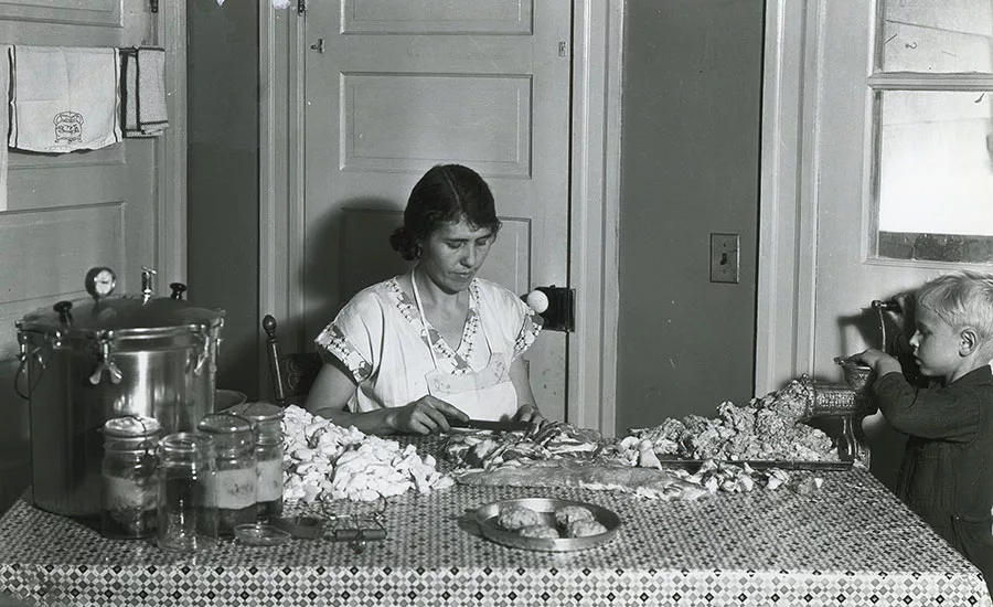 A woman and child make sausage from "less-choice cuts of pork" during the Great Depression
