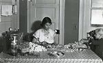 A woman and child make sausage from "less-choice cuts of pork" during the Great Depression