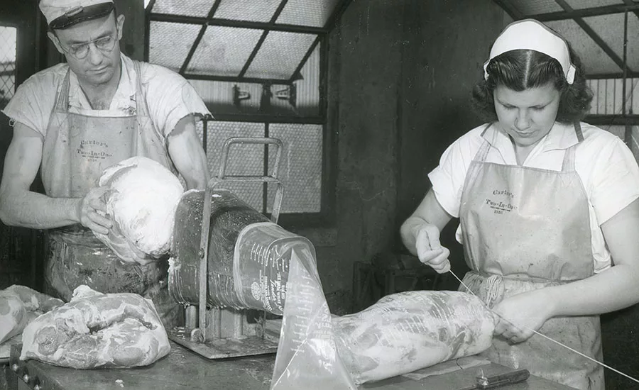 Armour employees prepare boneless hams for smoking