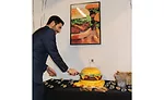 Jamie Schweid cuts into a burger-shaped cake