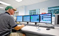 A meat & poultry plant worker uses a computer-based system for record keeping