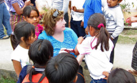 A Hormel Foods employee sits with Guatemalan children