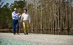 Pic Billingsley and Andy Hanacek walk along an earthen dam at Sanderson Farms’ St. Pauls, N.C., plant