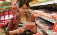 Woman Reading Ingredients on Food Label for Meat Product