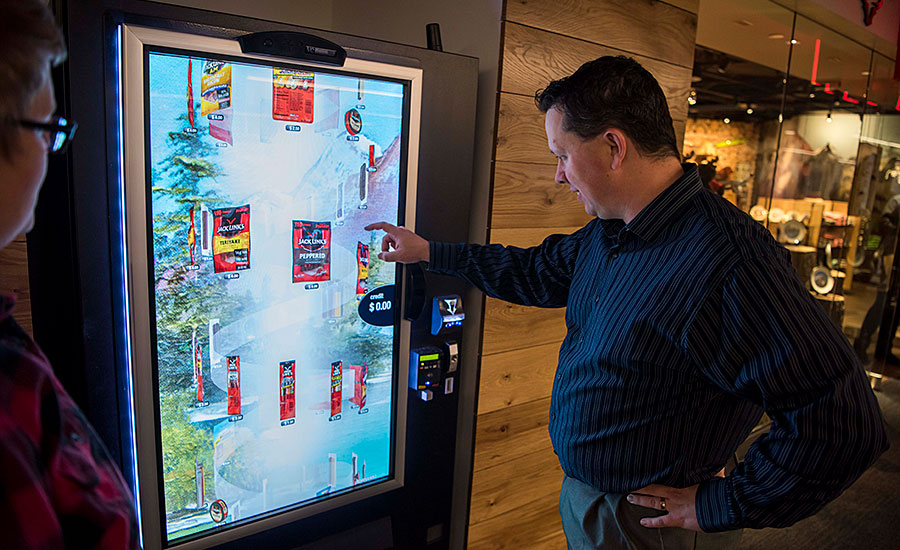 Andy Hanacek, Editor-in-chief of The National Provisioner, tests the Jack Link's Wild Side retail store meat snacks vending machine