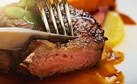 Knife and Fork Cutting Tender Piece of Beef