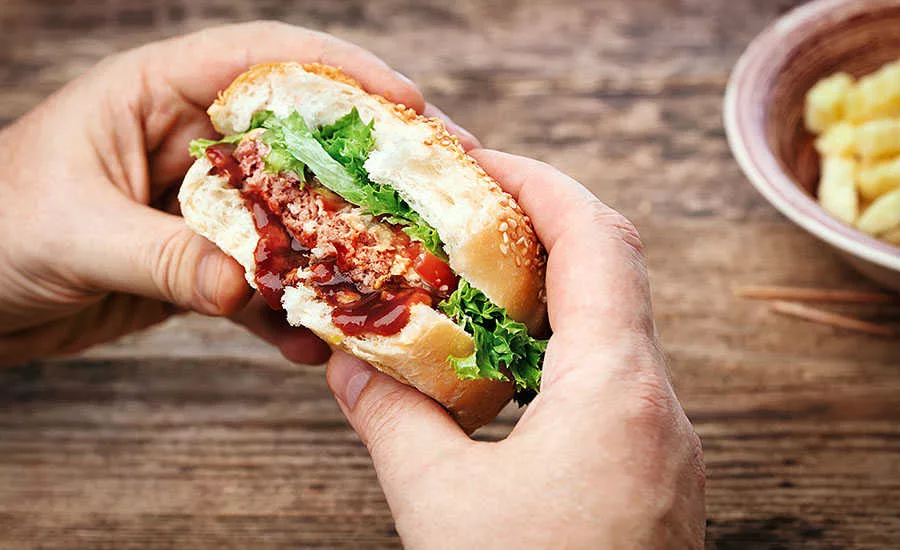 Hands Holding Half-Eaten Burger