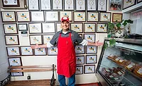 man in front of awards on a wall