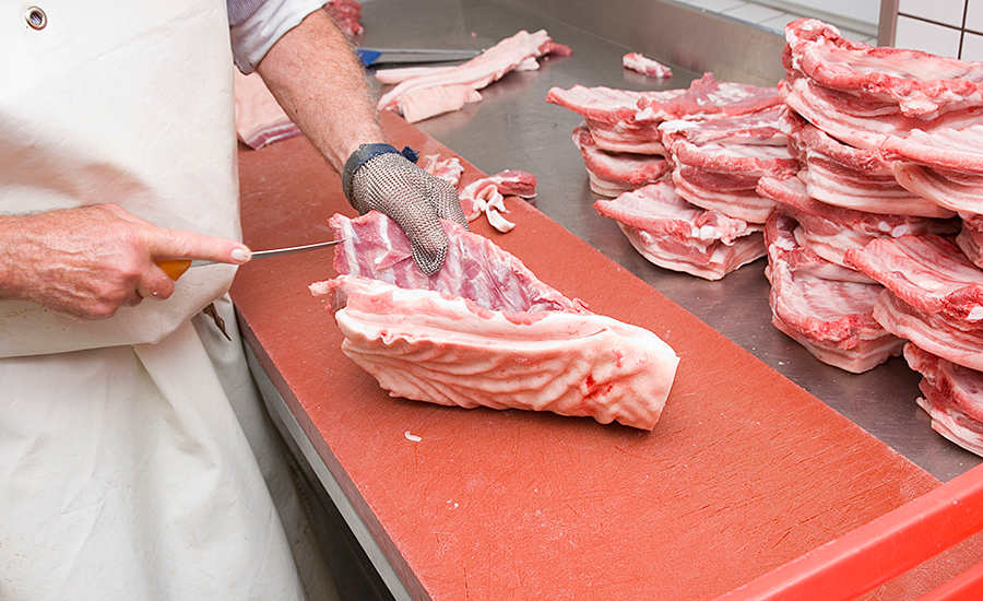 raw bacon being butchered