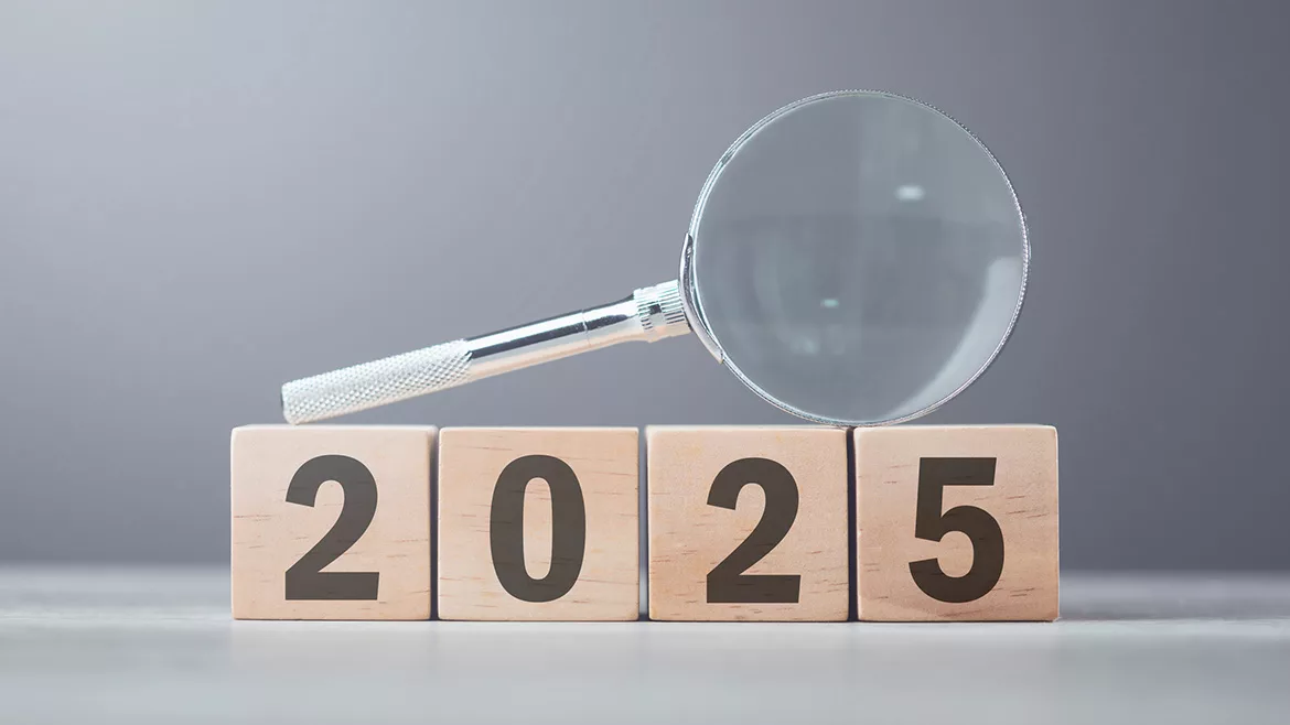 2025 wooden blocks with a magnifying glass laid on top.