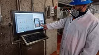A processor employee in safet gear using the CarVe system.