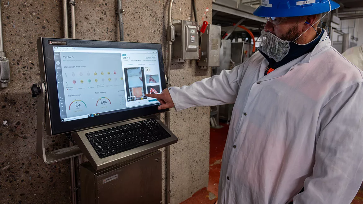 A processor employee in safet gear using the CarVe system.