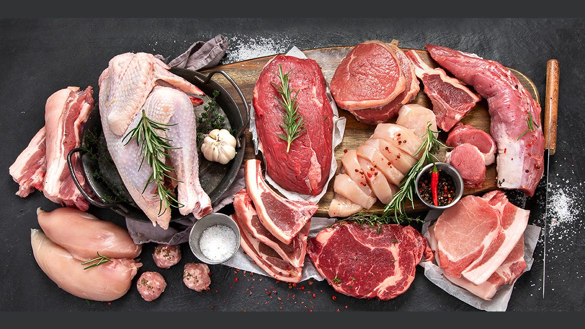 Several cuts of beef, pork and chicken on a wooden board, cast iron pan and salt.