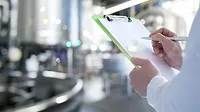 a professional conducting a food safety inspection in an industrial processing facility
