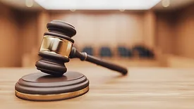 a wooden judge's gavel resting on a sound block