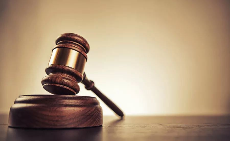 a wooden judge's gavel resting on a sound block