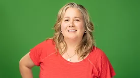 Anne Malleau headshot on a green background.