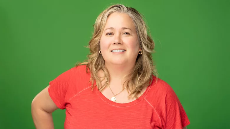 Anne Malleau headshot on a green background.