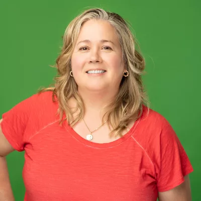 Anne Malleau headshot with green background, cropped to 400x400